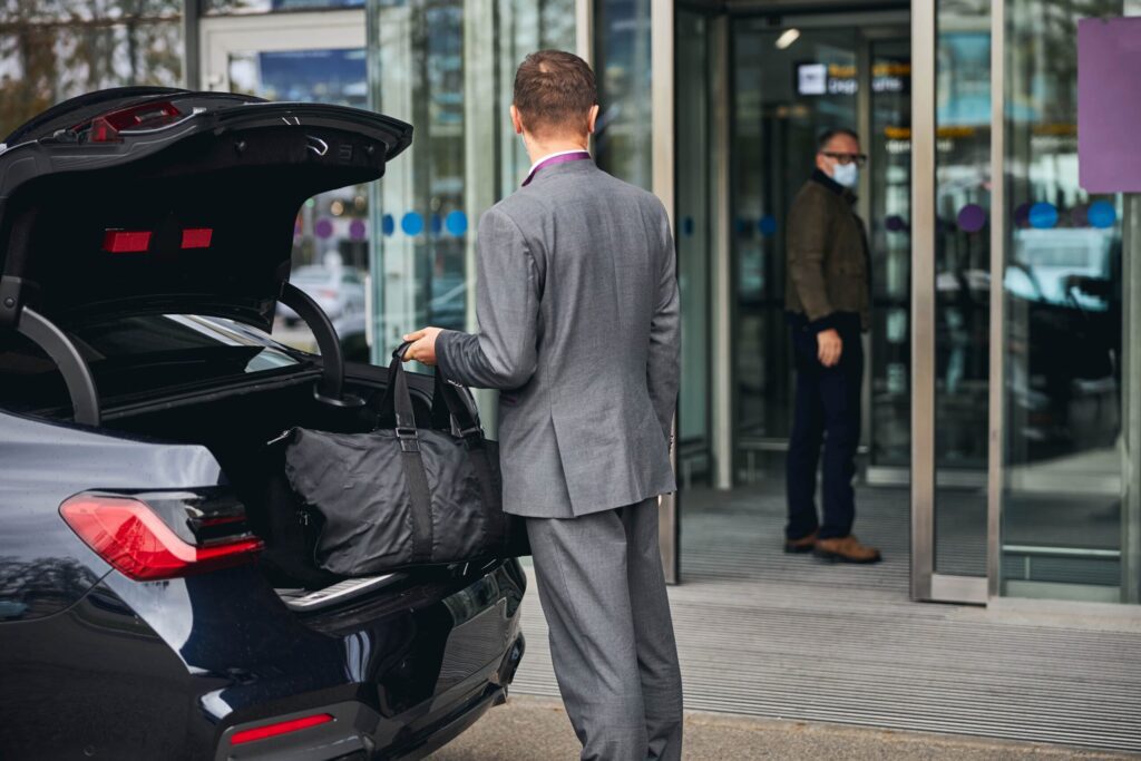 Airport Transfers: Taxis, Shuttles, and Private Cars | Elect Chauffeurs man loading luggage into private car transfer service